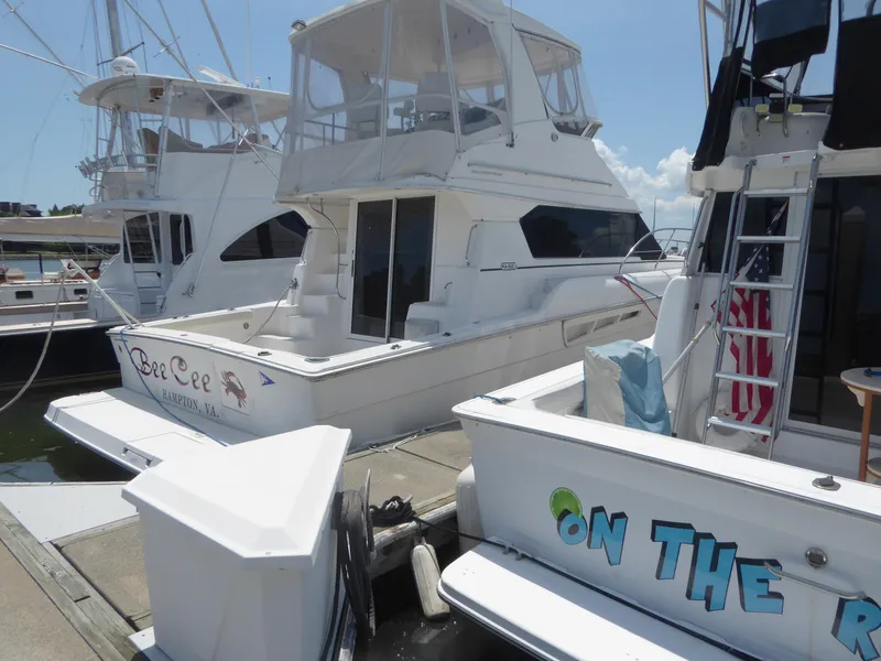 Slide: The Image of 2000 Silverton 42C Cummins 450 Diesels docked at marina, featuring multiple boats. - 4