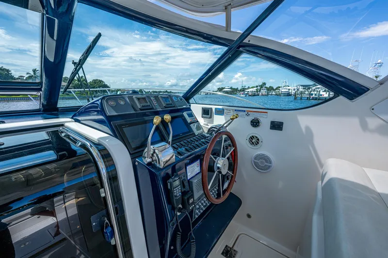 Slide: The Image of 2008 Tiara Yachts 3200 Open helm with modern controls and scenic marina view. - 28