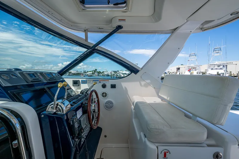 Slide: The Image of 2008 Tiara Yachts 3200 Open cockpit with helm, marina view, and clear blue sky. - 29