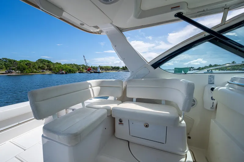 Slide: The Image of 2008 Tiara Yachts 3200 Open interior with white seating, overlooking serene water and lush greenery. - 31