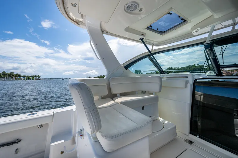 Slide: The Image of 2008 Tiara Yachts 3200 Open interior with white seating, overlooking serene waters. - 32
