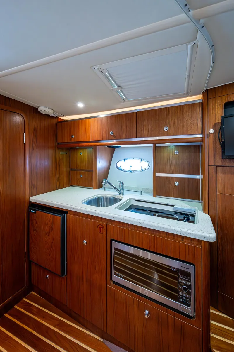 Slide: The Image of 2008 Tiara Yachts 3200 Open galley with wood cabinetry, sink, and microwave. - 37