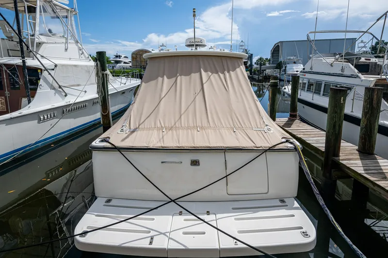 Slide: The Image of 2008 Tiara Yachts 3200 Open docked with beige cover, surrounded by other boats. - 44