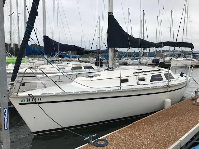 The Image of Hunter 28 sailboat from 1990 docked at a marina, surrounded by other boats. - 0