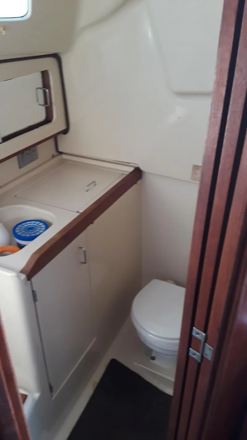 Slide: The Image of 1990 Hunter 28 sailboat bathroom with compact toilet and storage cabinets. - 12