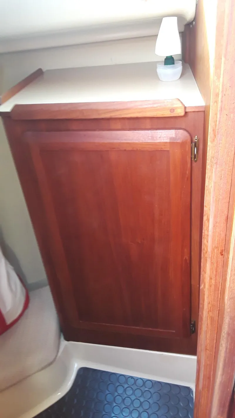 Slide: The Image of 1990 Hunter 28 interior with wooden cabinet and small lamp. - 17