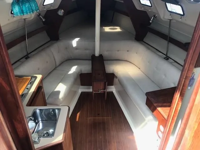 Slide: The Image of Interior of a 1990 Hunter 28 sailboat with cozy seating and compact kitchen area. - 2