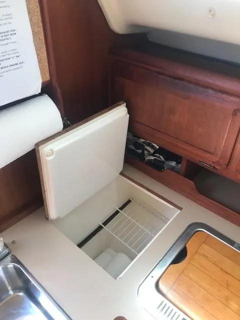 Slide: The Image of Interior of a 1990 Hunter 28 sailboat showing a compact kitchen area with storage. - 28