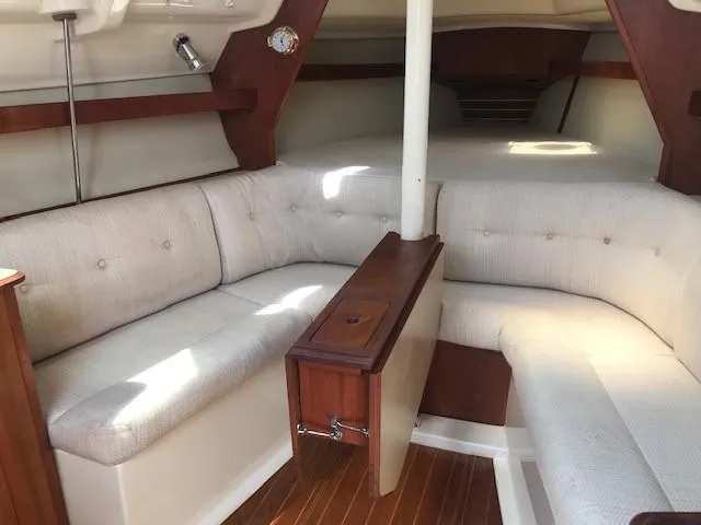 Slide: The Image of Interior of a 1990 Hunter 28 sailboat with cushioned seating and wooden accents. - 3