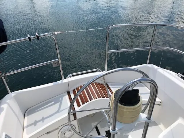 Slide: The Image of Cockpit of a 1990 Hunter 28 sailboat with steering wheel and water view. - 32