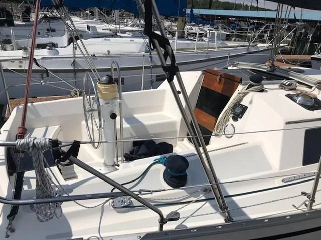 Slide: The Image of 1990 Hunter 28 sailboat cockpit with steering wheel and winches, docked at marina. - 33
