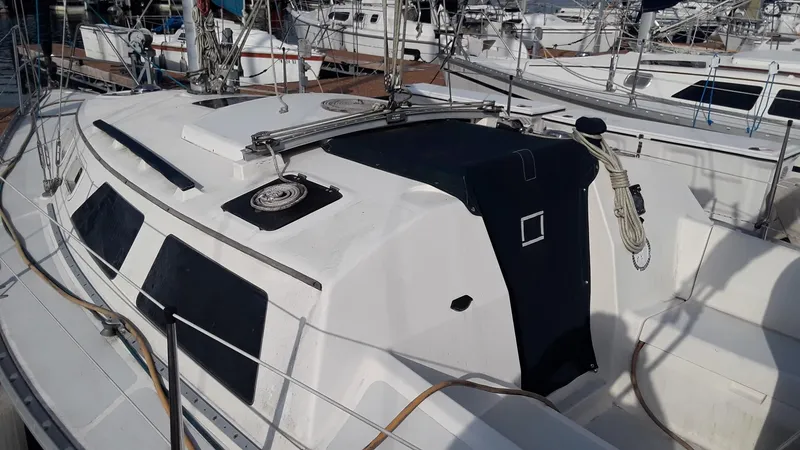 Slide: The Image of 1990 Hunter 28 sailboat docked in marina, featuring sleek white design and black accents. - 37