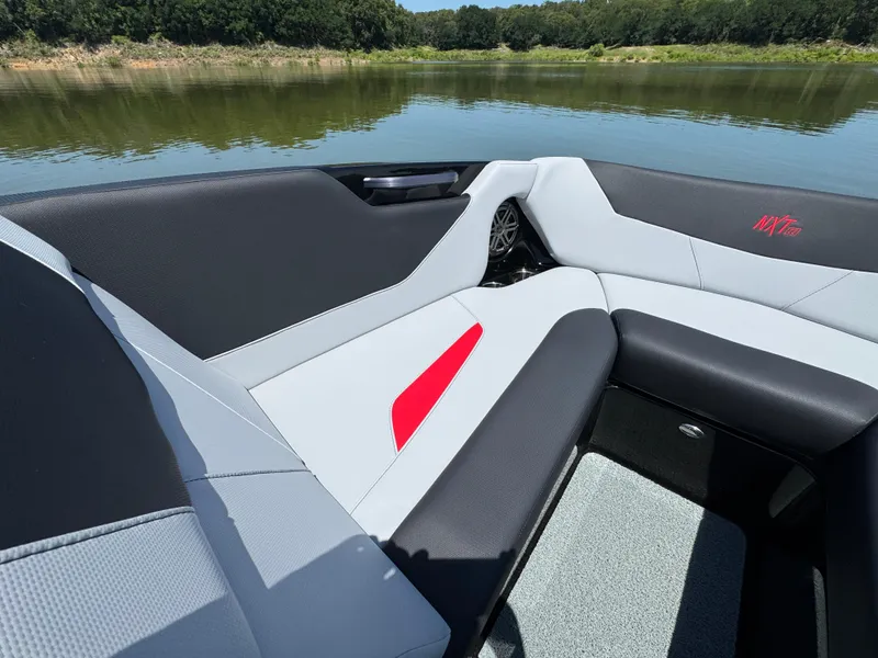 Slide: The Image of 2022 MasterCraft NXT22 boat interior with sleek seating and scenic lake view. - 10