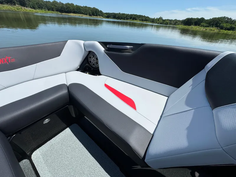 Slide: The Image of 2022 MasterCraft NXT22 boat interior with sleek seating and scenic lake view. - 11