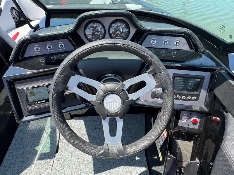 Slide: The Image of 2022 MasterCraft NXT22 boat dashboard with steering wheel and control panels. - 15