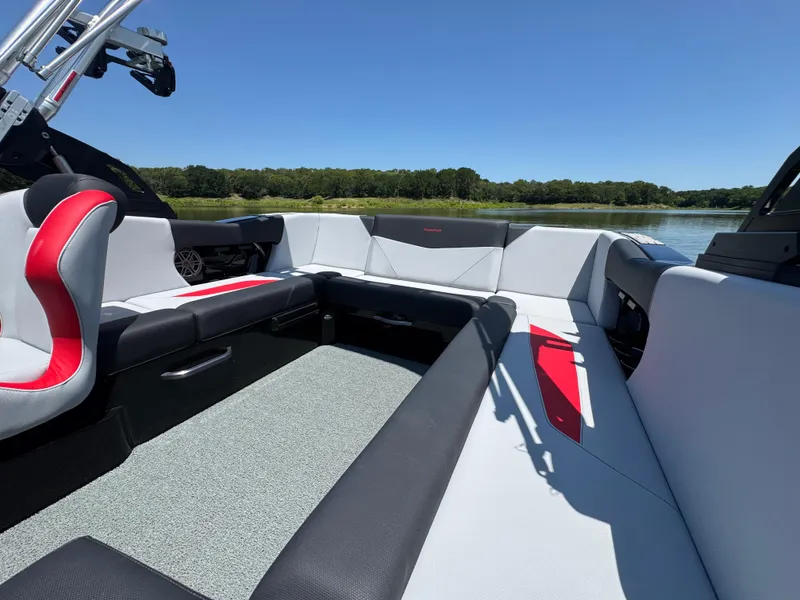 Slide: The Image of 2022 MasterCraft NXT22 boat interior with sleek seating and modern design on a sunny day. - 20