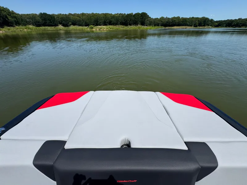 Slide: The Image of 2022 MasterCraft NXT22 boat on calm lake with lush green shoreline. - 21