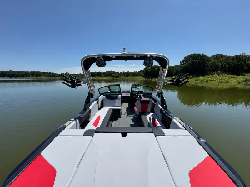 Slide: The Image of 2022 MasterCraft NXT22 boat on a calm lake, featuring sleek design and spacious seating. - 25