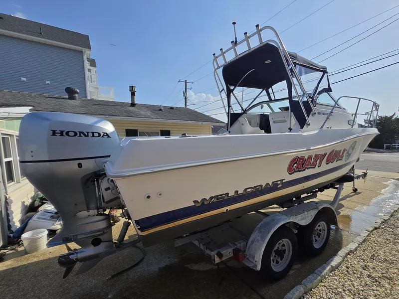 Slide: The Image of 1996 Wellcraft Excel 23 Walk Around boat with Honda outboard motor on trailer. - 11