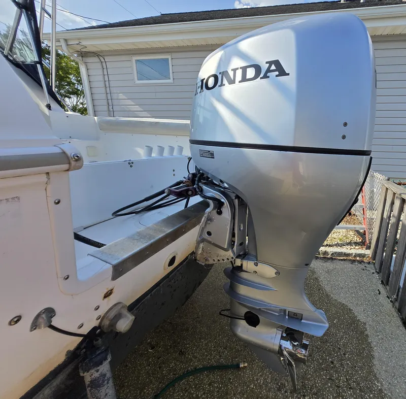 Slide: The Image of 1996 Wellcraft Excel 23 Walk Around with Honda outboard motor in a driveway. - 12
