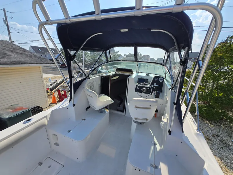 Slide: The Image of 1996 Wellcraft Excel 23 Walk Around boat interior with steering wheel and seating. - 2