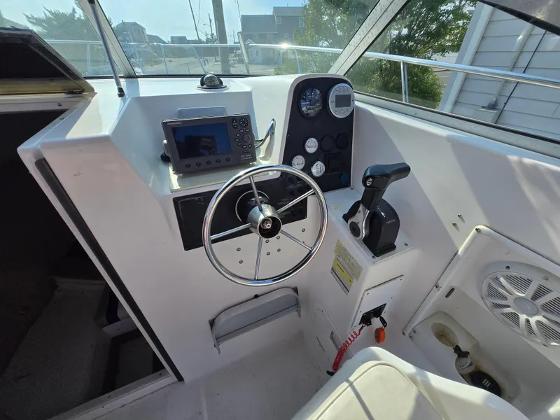 Slide: The Image of 1996 Wellcraft Excel 23 Walk Around boat cockpit with steering wheel and control panel. - 7