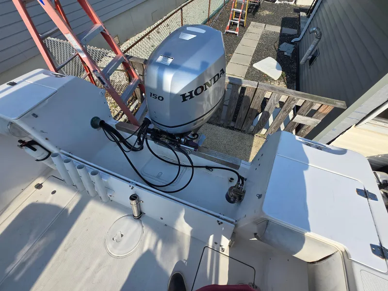 Slide: The Image of 1996 Wellcraft Excel 23 Walk Around boat with Honda 150 outboard motor, docked near a house. - 8