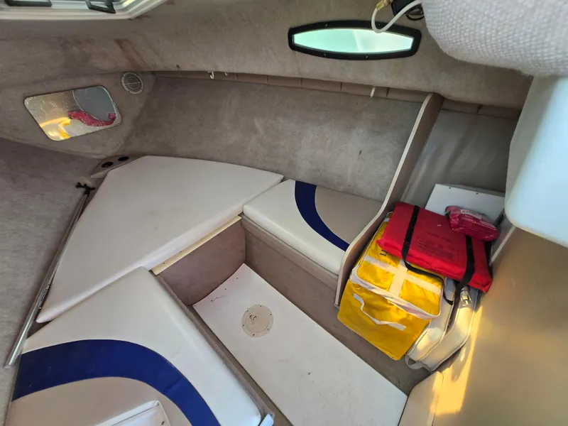 Slide: The Image of Interior cabin of a 1996 Wellcraft Excel 23 Walk Around boat, featuring seating and storage. - 9