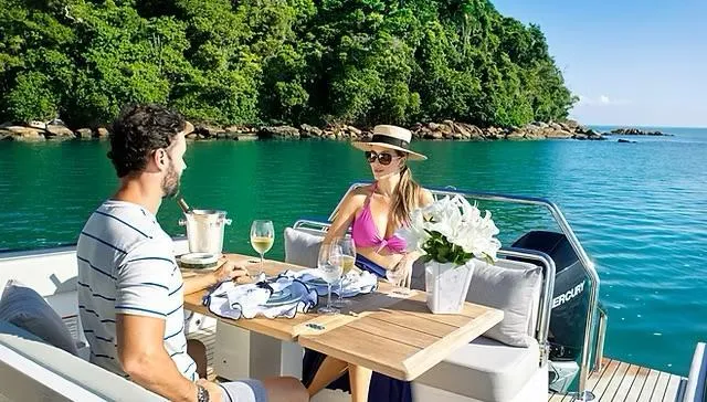 Slide: The Image of Couple enjoying a meal on a 2025 Schaefer V33 yacht, surrounded by scenic ocean views. - 36