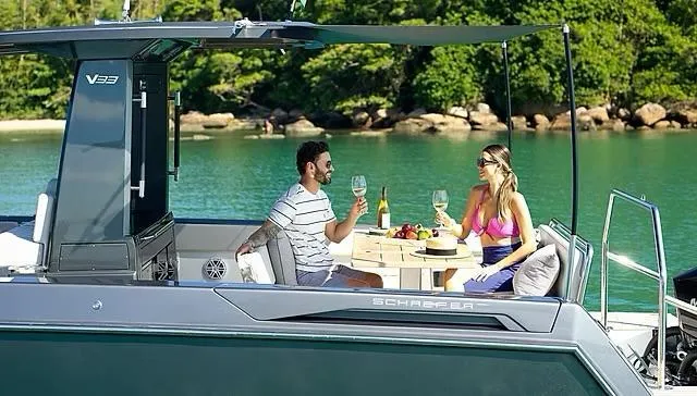 Slide: The Image of Couple enjoying drinks on a 2025 Schaefer V33 yacht in a scenic bay. - 37