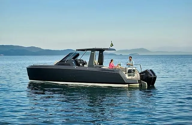 Slide: The Image of 2025 Schaefer V33 boat cruising on calm waters with scenic mountain backdrop. - 3