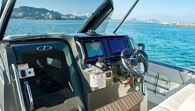 Slide: The Image of Cockpit of 2025 Schaefer V33 boat with modern navigation systems, steering wheel, and ocean view. - 5