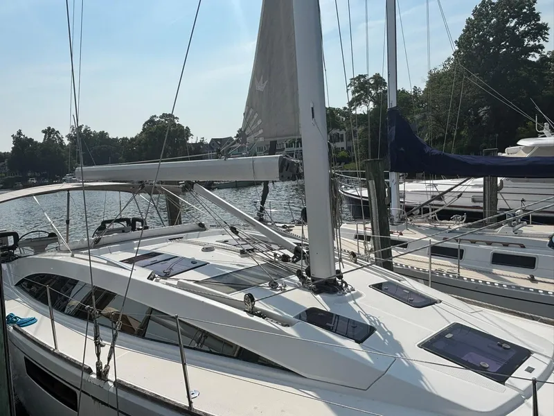 Slide: The Image of 2012 Bavaria Vision 46 sailboat docked at a marina, featuring sleek design and modern rigging. - 2