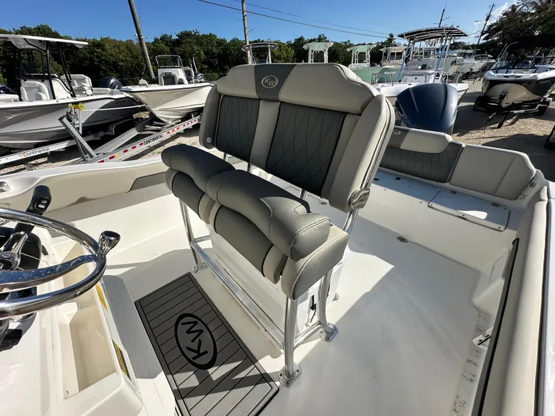 Slide: The Image of 2025 Key West 239 FS boat interior with cushioned seating and steering wheel. - 14