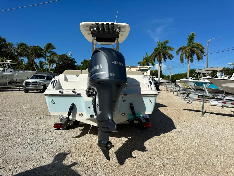Slide: The Image of 2025 Key West 239 FS boat with Yamaha engine, parked on gravel lot with palm trees. - 4