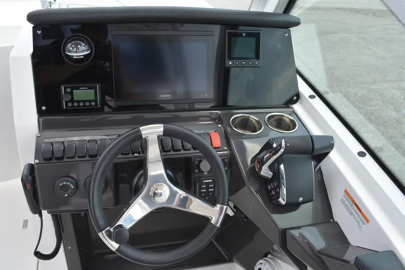 Slide: The Image of 2026 Blackfin 252 DC boat dashboard with steering wheel, controls, and digital displays. - 17