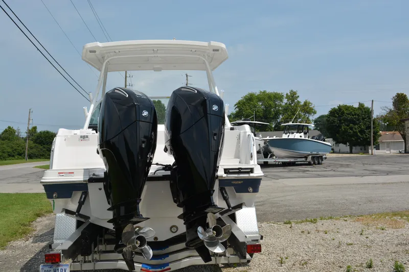 Slide: The Image of 2026 Blackfin 252 DC boat with dual outboard engines, parked on a trailer. - 3