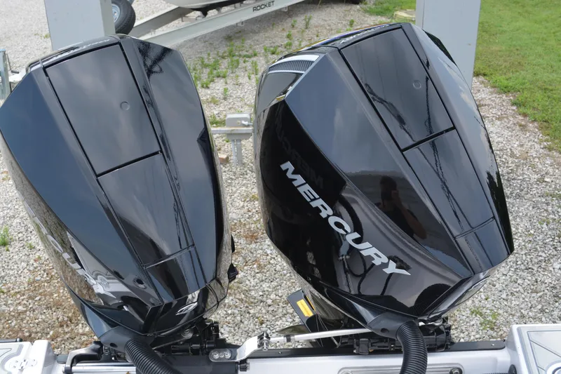 Slide: The Image of Dual Mercury outboard engines on 2026 Blackfin 252 DC boat, parked on gravel. - 33