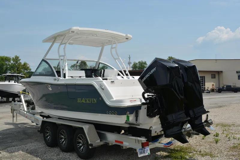 Slide: The Image of 2026 Blackfin 252 DC boat on trailer with dual Mercury engines, parked outdoors. - 4