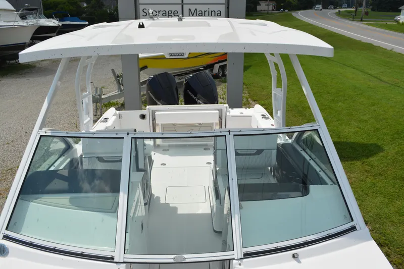 Slide: The Image of 2026 Blackfin 252 DC boat with dual engines, parked near a marina. - 9