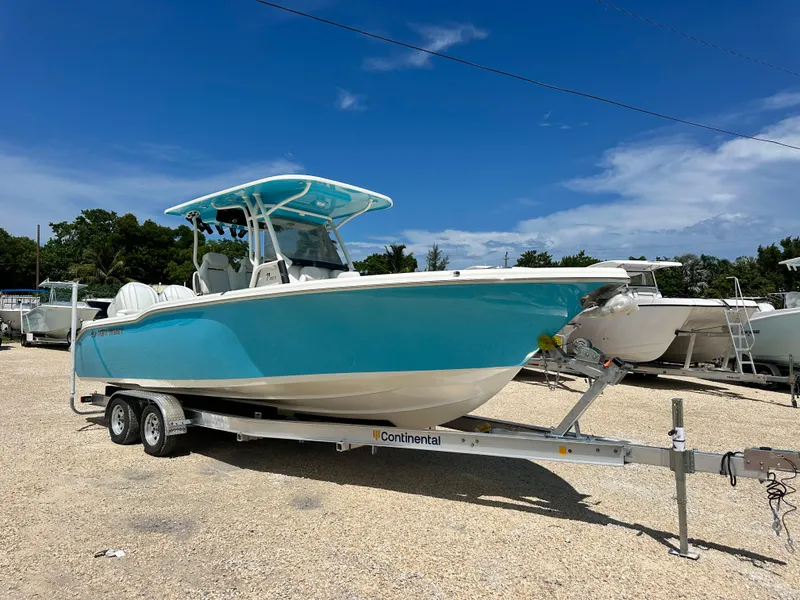Slide: The Image of 2025 Key West 263 FS boat on trailer under clear blue sky. - 1