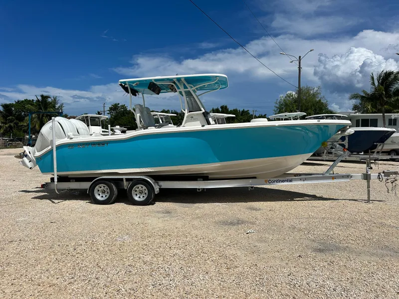 Slide: The Image of 2025 Key West 263 FS boat on trailer, vibrant blue hull, parked outdoors. - 2