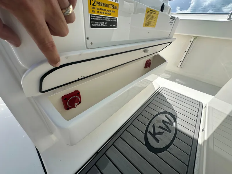 Slide: The Image of 2025 Key West 263 FS boat interior, showing storage compartment and KW-branded flooring. - 20