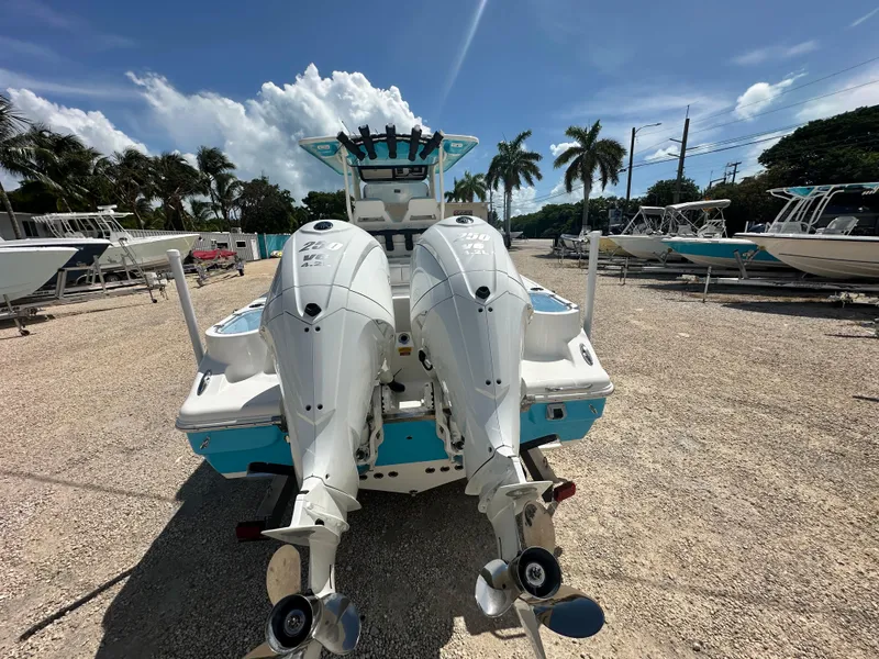 Slide: The Image of 2025 Key West 263 FS boat with dual outboard engines in a sunny marina. - 4