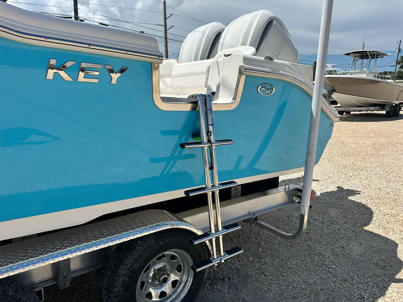 Slide: The Image of 2025 Key West 263 FS boat with blue hull and ladder on trailer. - 6