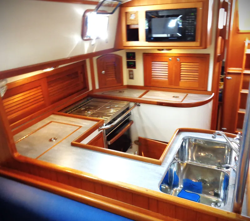 Slide: The Image of Interior of 2005 Pacific Seacraft 40 yacht kitchen with wood cabinetry and stainless steel sink. - 4