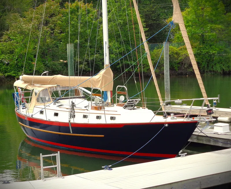 Slide: The Image of Sailboat docked in a serene marina, Pacific Seacraft 40, 2005 model, surrounded by lush greenery. - 10