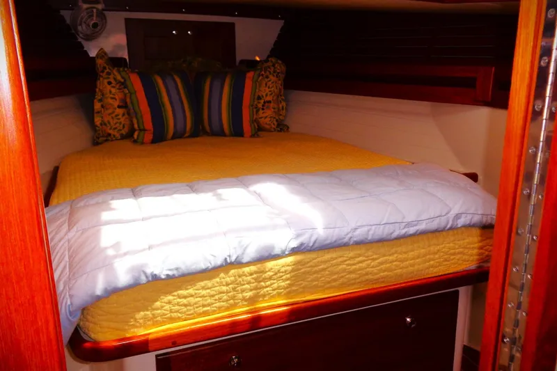 Slide: The Image of Cozy cabin interior of 2005 Pacific Seacraft 40 with colorful bedding and wooden accents. - 5