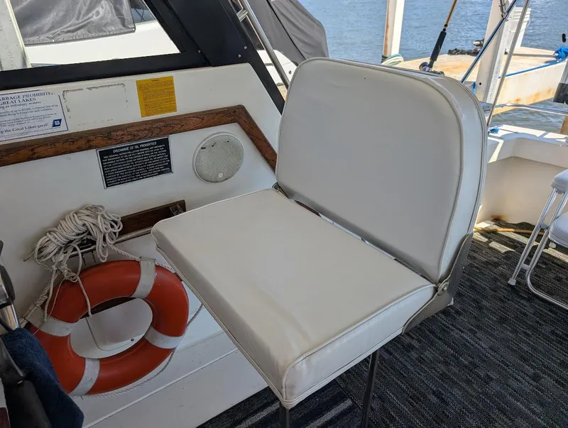 Slide: The Image of 1977 Trojan F30 Express boat interior with white seat, life preserver, and nautical equipment. - 18