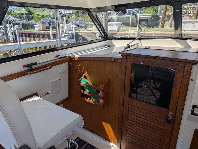 Slide: The Image of 1977 Trojan F30 Express boat interior with wooden cabinetry and white seating. - 20